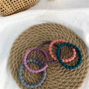 Set of 5 colorful high-elastic wavy knitted hair ties on a rustic woven background