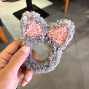 Detailopname van de zachte grijze pluche kattenoor haarelastiekjes met roze accenten