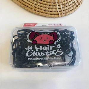 Detail showing high-elasticity black hair ties in a clear storage box for kids