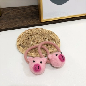 Dettaglio di due simpatici elastici per capelli a forma di maialino in feltro rosa