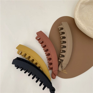 Matte finish large banana hair clips in dark autumn colors like black and mustard