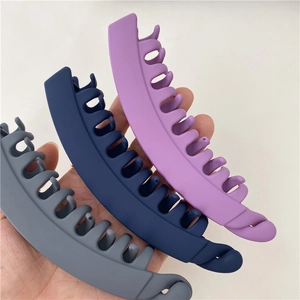 Three matte finish banana hair clips in dark grey, navy blue, and lavender colors