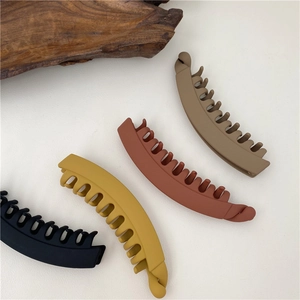 Set of four matte Morandi color banana hair clips in black, yellow, brown, and tan