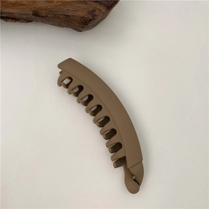 Detailed macro view showing the matte brown texture and dense teeth of the banana hair clip