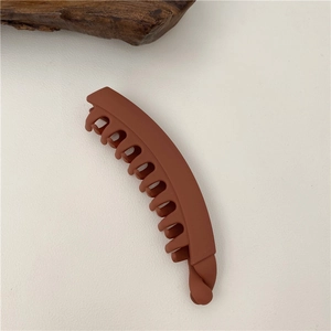 Macro shot of matte dark red banana hair clip with secure interlocking teeth
