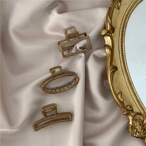 Three-piece set of wooden texture hair claws on satin fabric with a vintage gold mirror