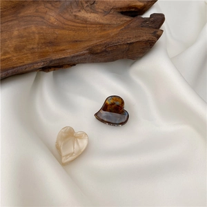 Elegant heart-shaped mini hair clips in tortoiseshell and marble white patterns
