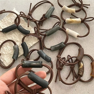 Details der koreanischen elastischen Haargummis mit marmorierten Harzperlen in der Hand
