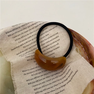 Détail d'un élastique à cheveux en résine ambrée élégant sur fond de tissu vintage
