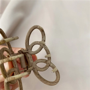Detailed view of a vintage wood-texture alloy hair claw clip with geometric hollow design