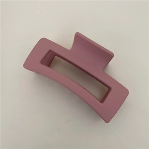 Close-up of matte dusty pink rectangular hair claw clip with a hollow geometric design