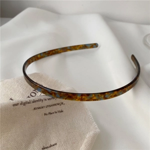 Detail of slim acetate headband with amber tortoiseshell and light blue accents