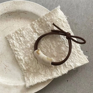 Detailaufnahme der Marmor-Muster Perle am minimalistischen Bogen Haargummi