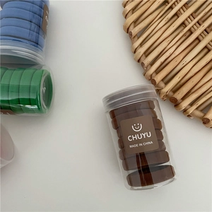 Close-up of colorful seamless elastic hair ties in a clear plastic storage container