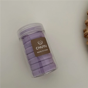 Close-up of purple elastic hair ties neatly stored in a clear plastic storage jar