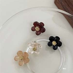 Mini bloemen haarclip set met parels en strass in vier kleuren op een glazen dienblad