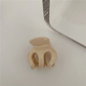 Close-up of a milk tea colored medium hair claw clip in a minimalist Korean style setting
