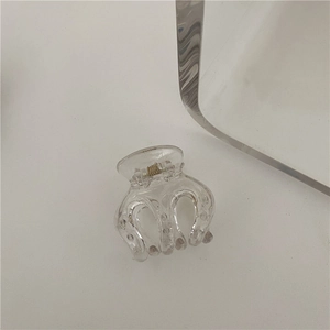 Detail of transparent shark hair claw clip with metallic spring and dot texture