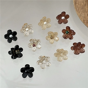 Detailopname van mini bloemen haarklemmen met parels en strass op glazen oppervlak