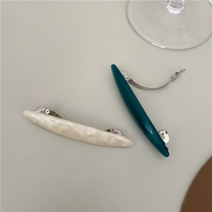 Detail view of acetate leaf hair clips with marble texture and silver metal clips