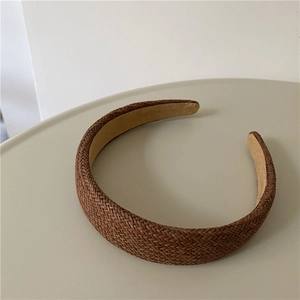 Close-up of caramel brown woven headband with herringbone texture and soft suede lining