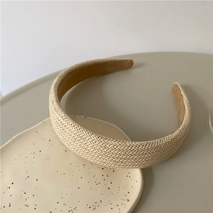 Detail view of woven beige straw headband with textured Raffia finish and soft inner lining