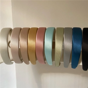Collezione di cerchietti in spugna satinata in dieci colori esposti su un supporto