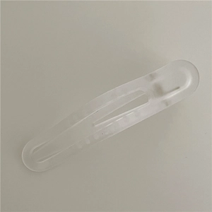 Detail einer matt-transparenten weißen Haarklammer im hohlen Wassertropfen-Design