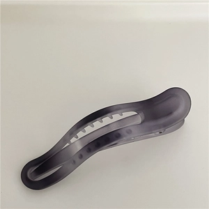 Makrodetail der durchscheinenden, mattgrauen Haarklammer mit ergonomisch geschwungenem Design
