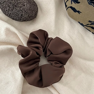 Elegant dark brown satin scrunchie with soft pleated texture for hair styling