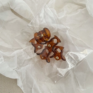 Détail de mini pinces à cheveux en écaille de tortue ambre avec ressorts métalliques