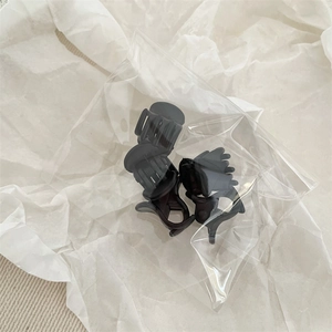 Détail de trois mini pinces à cheveux noires en plastique avec ressort métallique