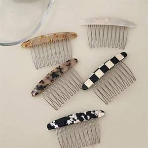 Detailed view of checkered and marble acetate hair combs with durable metal teeth