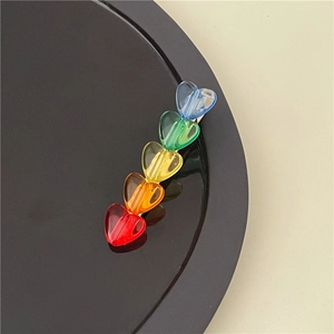 Dettaglio di un fermaglio per capelli arcobaleno con cuori colorati in resina