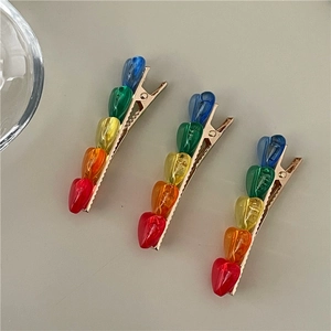 Set di tre fermagli per capelli a cuore arcobaleno con base in lega dorata e resina colorata