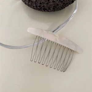 Detail of Korean style marble texture hair comb with silver metal teeth on glass plate