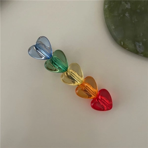 Dettaglio del fermaglio per capelli arcobaleno con cuori in resina colorata