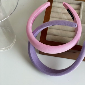 Detail of pink and purple padded sponge headbands showing handmade woven labels
