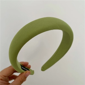 Detail of avocado green padded sponge headband with handmade label and twill fabric