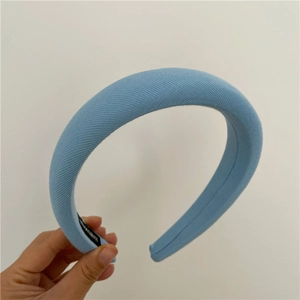 Detail of light blue padded sponge headband featuring a handmade fabric label on interior