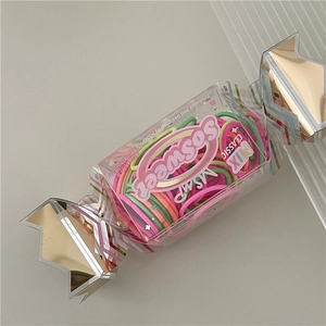 Close-up of assorted colorful kids hair bands in a sweet candy-shaped packaging box