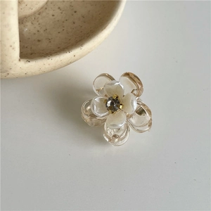Vue détaillée d'une mini pince à cheveux fleur ambre avec perle et centre en strass