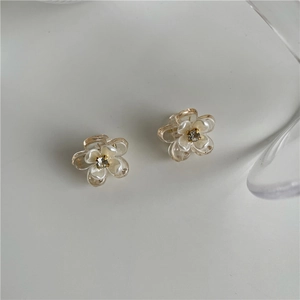 Vue détaillée de pinces à cheveux en fleur de résine avec strass central et nacre polie