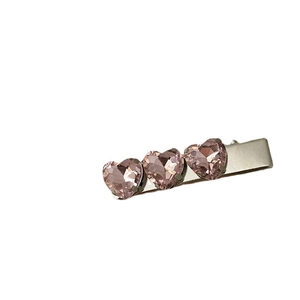 Fermaglio in metallo argentato con tre cristalli a cuore rosa e design a becco d'oca