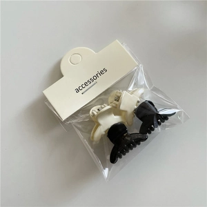 Detail view of 2-piece mini jelly color bow hair clips in black and white with packaging