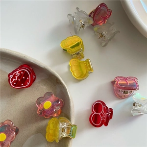 Détail de mini pinces à cheveux en acrylique aux formes de fraise et fleur