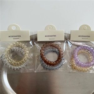Detalle de seis gomas de pelo de cable telefónico en tarjetas de papel minimalistas