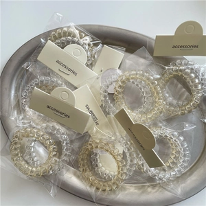 Set de gomas para el pelo en espiral transparentes y ámbar en bandeja de metal