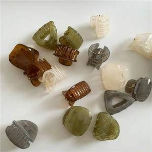 Variety of geometric resin hair clips in earth tones like amber and olive green