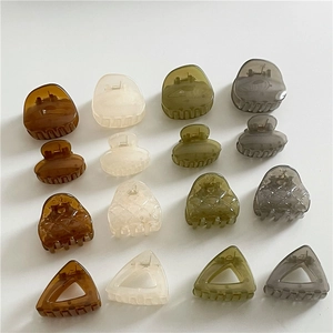 Detailed grid of geometric resin hair claws in tortoiseshell, olive, and grey tones